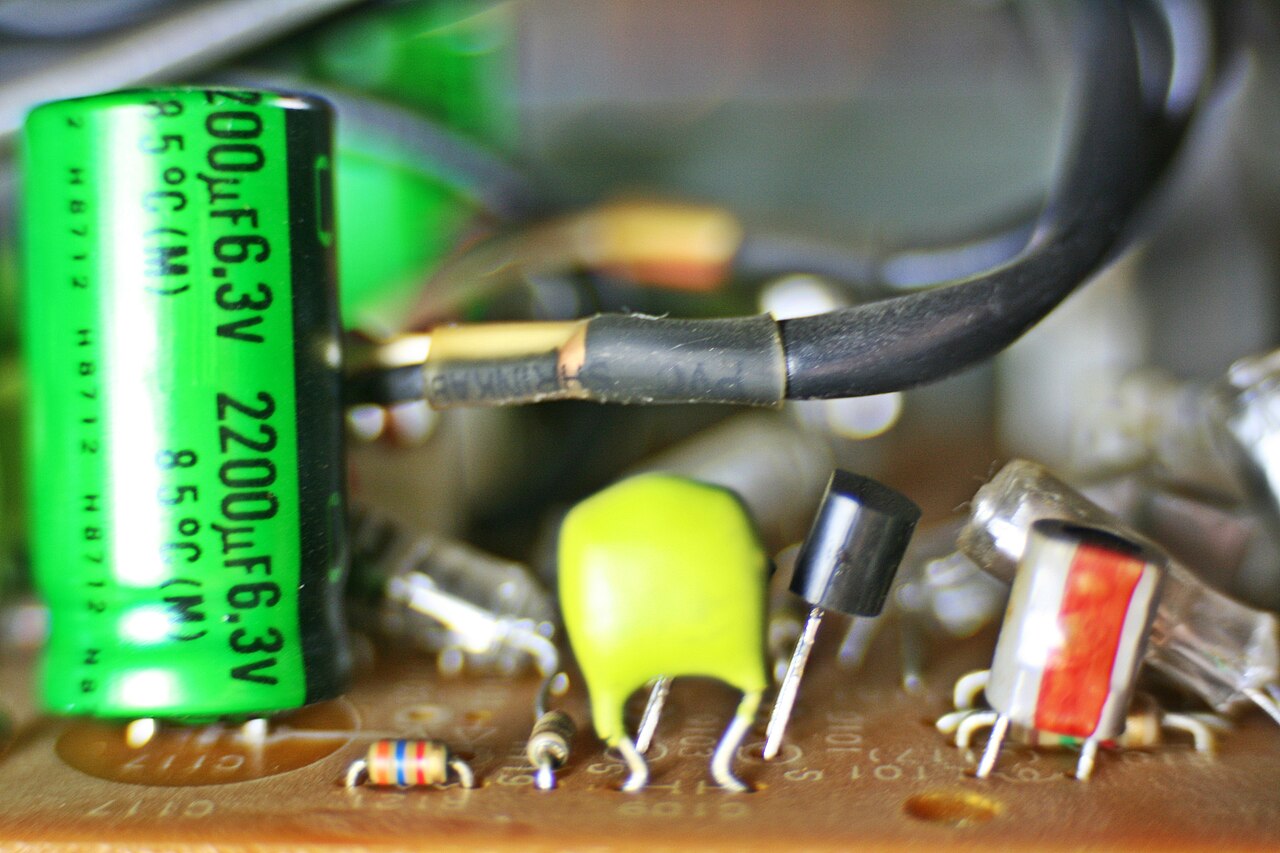 Close view of capacitors and components on a green circuit board